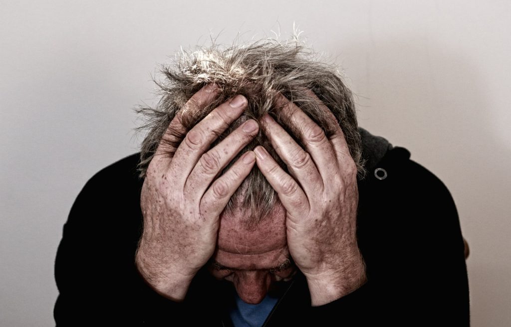 Man feeling stressed out rubbing his head